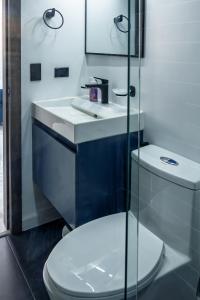 a bathroom with a toilet and a sink at Galería 305 in Cartago +18 photos