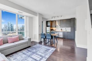 a living room with a couch and a table with chairs at Eleve Toronto Residences in Toronto