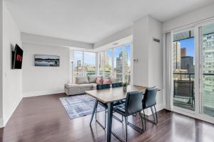 a dining room with a table and chairs and a couch at Eleve Toronto Residences in Toronto