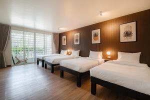 a room with three beds with white sheets at SOL HOUSE kohlarn in Ko Larn