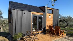 a tiny house with a deck and chairs at Intermezzo X by Tiny Away in Citta' Sant'Angelo