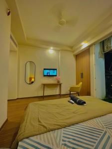 a bedroom with a bed and a tv on the wall at Paradise Stays in Greater Noida