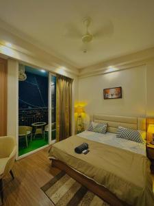 a bedroom with a bed and a room with a table at Paradise Stays in Greater Noida