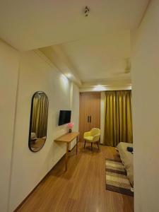 a bedroom with a bed and a mirror and a desk at Paradise Stays in Greater Noida