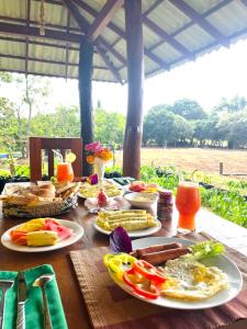 a wooden table with plates of food on it at Green Heaven Sigiriya in Sigiriya