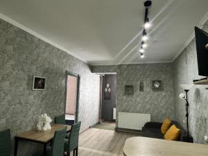 a living room with a table and a couch at Marina Apartments in Gudauri