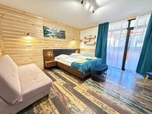 a bedroom with a bed and a couch and a chair at Vila Arina -Private Retreat in Voronet +50 photos
