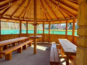 a wooden pavilion with benches and a table in it at Vila Arina -Private Retreat in Voronet