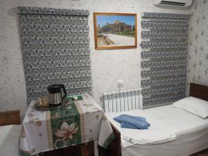 a small room with two beds and a table at Sohibqiron boutique in Bukhara