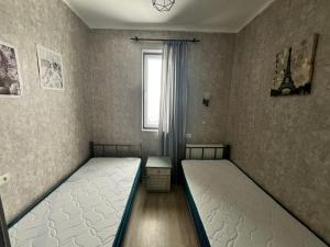 two twin beds in a room with a window at Marina Apartments in Gudauri