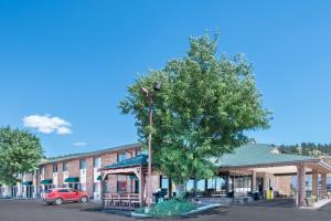 a building with a tree in front of a building at Days Inn by Wyndham Spearfish in Spearfish