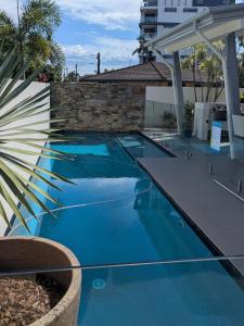 a swimming pool with blue water in front of a building at Luxury House steps from Mooloolaba Beach in Mooloolaba