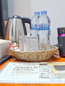 Ein Korb mit Wasserflaschen und Gläsern auf einem Tisch in der Unterkunft SANDB Hotel in Ko Phangan
