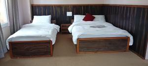 two twin beds in a room withskirts at Hotel Himalayan Vista in Pāti Bhanjyāng