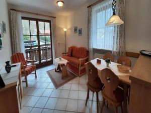 a living room with a couch and a table and chairs at Beautiful lodging in the Alps near Bayrischzell in Bayrischzell