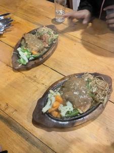 two plates of food on a wooden table at Hotel Himalayan Vista in Pāti Bhanjyāng