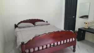 a bedroom with a wooden bed with two pillows at NISETH Home in Phumĭ Réach Born (2)