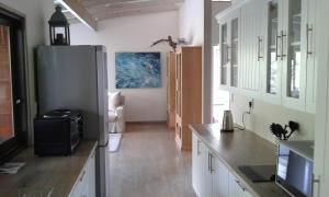 a kitchen with a stainless steel refrigerator in a room at Kamma-Otter in Natureʼs Valley