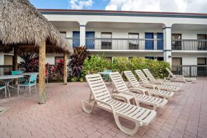 a row of lounge chairs and tables in front of a building at Days Inn by Wyndham Florida City in Florida City