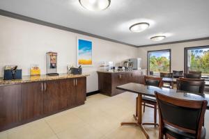 a restaurant with a table and chairs and a kitchen at Days Inn by Wyndham Florida City in Florida City