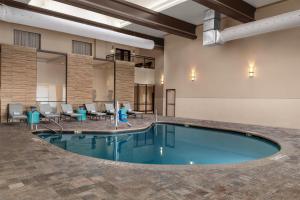a pool in the lobby of a hotel with tables and chairs at Doubletree By Hilton Lubbock - University Area in Lubbock