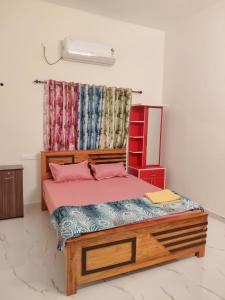 a bedroom with a wooden bed with pink sheets at Star Varkala Homestay in Varkala