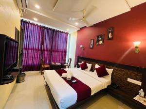 a bedroom with a large bed with red walls at Hotel Nisha in Mahabaleshwar