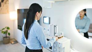 a woman is putting a cupcake in a microwave at Busan Ieumjae Seomyeon Station in Busan