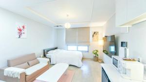 a living room with a bed and a couch at Busan Ieumjae Seomyeon Station in Busan