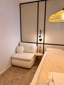 a room with a bed and a chair and a lamp at Przystań NADOLE- APARTAMENT in Nadole