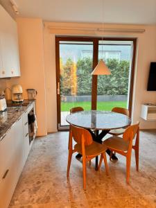 a kitchen with a table and chairs and a window at Przystań NADOLE- APARTAMENT in Nadole +12 photos