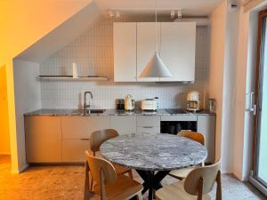 a kitchen with a table and chairs in a kitchen at Przystań NADOLE- APARTAMENT in Nadole