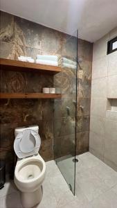 a bathroom with a toilet and a glass shower at Casa Mercedes in Valladolid +31 photos