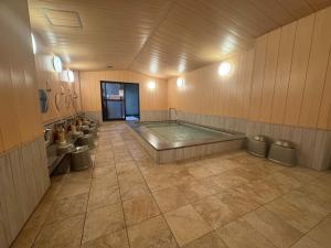 a large bathroom with a hot tub and toilets at Ishicho in Kyoto