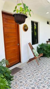 a porch with a wooden door and a chair and a potted plant at Casa Mercedes in Valladolid