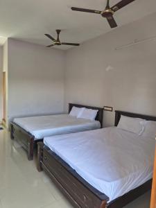 two beds sitting next to each other in a bedroom at APM Palace in Palaiya Ayakkudi
