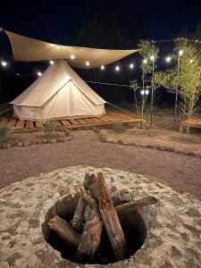 a tent with a pile of logs in front of it at Finca los ciervos in Apan