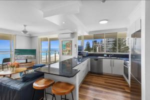 a kitchen and living room with a couch and a table at Viscount on the Beach in Gold Coast