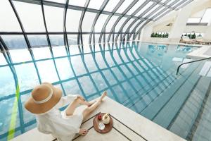 a woman sitting next to a swimming pool at Jumeirah Nanjing in Nanjing