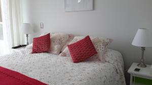 a bedroom with a bed with four pillows on it at Ovaser I in Coquimbo