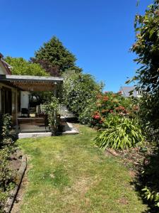 a yard with a bench and some bushes and flowers at Villa in the Vines in Martinborough