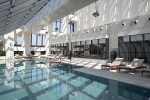 a large swimming pool with chairs in a building at Jumeirah Nanjing in Nanjing