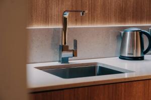 a kitchen sink with a faucet on a counter at Clarion Hotel Townsville in Townsville +21 photos