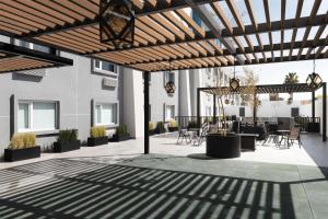 a patio with a wooden pergola with tables and chairs at Tru by Hilton Saltillo in Saltillo