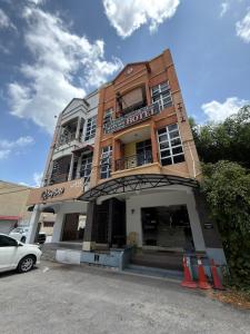 a building with a hotel with a car parked in front at MyPlace Sri Cemerlang Kota Bharu in Kota Bharu