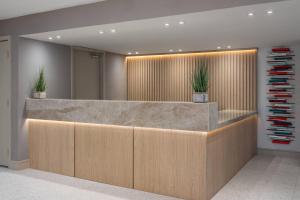 an office lobby with a reception desk with plants at The Harrison Hotel Downtown Hollywood FL, an Ascend Collection Hotel in Hollywood