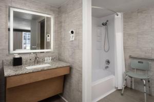 a bathroom with a sink and a tub and a mirror at The Harrison Hotel Downtown Hollywood FL, an Ascend Collection Hotel in Hollywood +66 photos