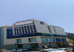 a building with cars parked in front of it at hotel mon ville alkapuri in Vadodara