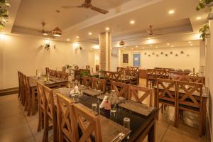 a restaurant with tables and chairs in a room at Munnar Ice Queen Resorts in Munnar