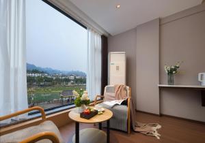 a living room with a table and a large window at Zhangjiajie Zhenxi Hotel- Near Forest Park EastGate about 10 Min Walk - English Butler, Free Luggage Storage, Tour Plan -reserve tickets for various scenic spots-Self-Service Laundry,Free coffee, Chinese tea in Zhangjiajie